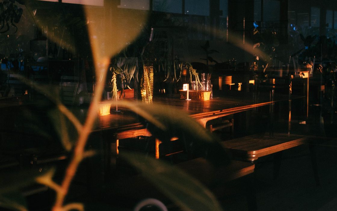 A dark, quiet room with wooden tables lit by small lamps